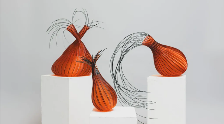 Three contemporary orange woven vases with black accents displayed on white pedestals